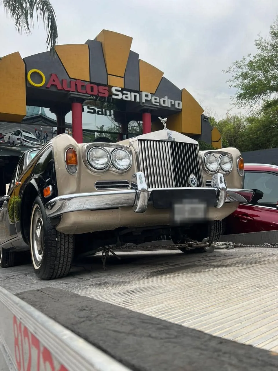 Rolls-Royce clásico asegurado con cadenas sobre la plataforma de la grúa